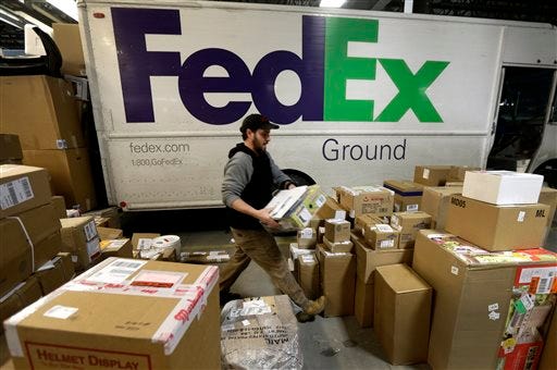 In this Dec. 16, 2013 file photo, package handler Chris Addison arranges packages before loading a delivery truck at a FedEx sorting facility in Kansas City, Mo. Santa's sleigh didn't make it in time for Christmas for some this year due to shipping problems at UPS and FedEx.The delays were blamed on poor weather earlier this week in parts of the country as well as overloaded systems.