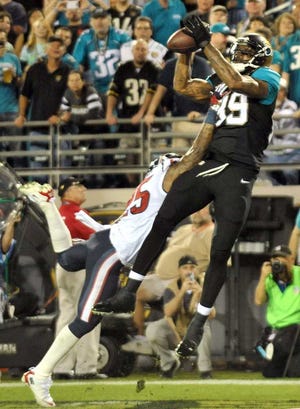 Marcedes Lewis pulls in a pass for a touchdown in the first quarter as Texans cornerback Kareem Jackson defends at EverBank Field on Dec. 5.  Bob.Self@jacksonville.com