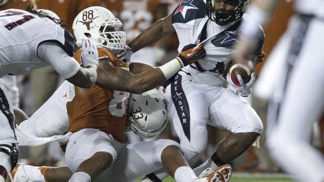 Texas defensive end Cedric Reed (88), tackling Texas Tech running back Kenny Williams in the Longhorns’ win Thanksgiving night, finished second on the team in sacks and tackles and has a tough choice to make: Leave Texas a year early for the NFL, or return for his senior season.