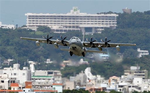 In this Aug. 16, 2012 photo, a C-130 transport plane takes off from the U.S. Marine Corps base in Futenma , in Okinawa, Japan. Okinawa Gov. Hirokazu Nakaima signed off Friday, Dec. 27, 2013, on the long-awaited relocation of the U.S. military base, a major step toward allowing the U.S. to move forward with plans to consolidate its troops in Okinawa and move some to Guam. Nakaima approved the Japanese Defense Ministry's application to reclaim land for a new military base on Okinawa's coast. It would replace the U.S. Marine Corps base in Futenma, a more congested part of Okinawa's main island. (AP Photo/Greg Baker)