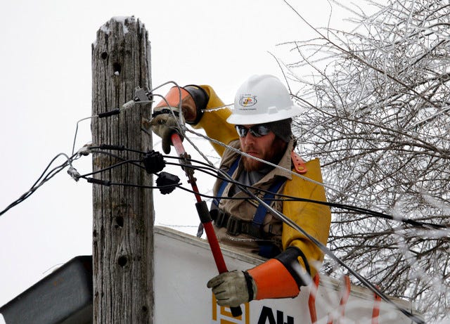 THE ASSOCIATED PRESS / Cory Bean works atop a utility pole to repair a power line Thursday, Dec. 26, 2013, in East Lansing, Mich. 
 THE ASSOCIATED PRESS / Karen Gibbs walks through a labyrinth of icy broken trees and downed power lines to her home in Belgrade, Maine on Thursday, Dec. 26, 2013.