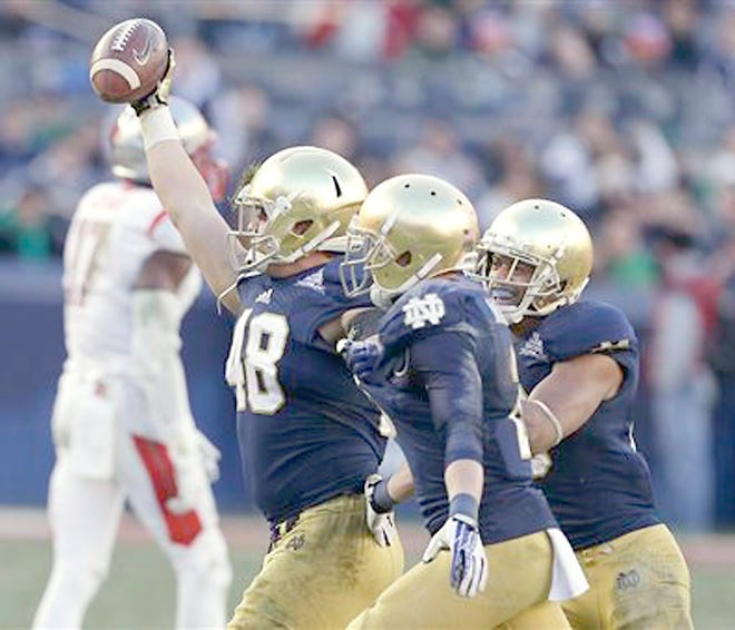 Notre Dame's Dan Fox (48) celebrates an interception with teammates during the second half of Saturday's Pinstripe Bowl viictory over Rutgers at Yankee Stadium.



AP Photo/Frank Franklin II