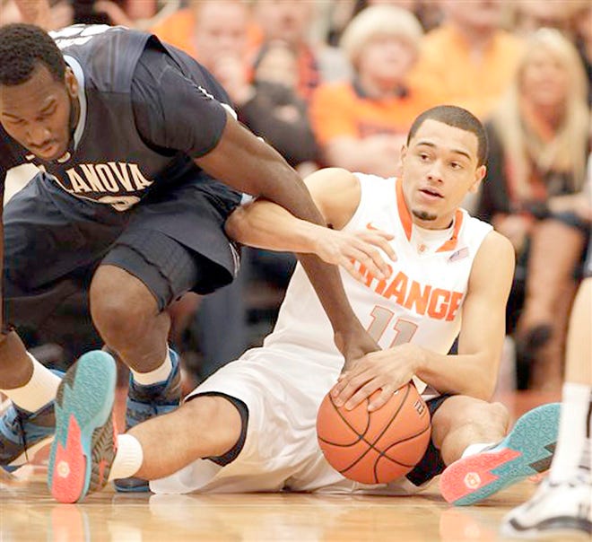 Syracuse's Tyler Ennis (right) and VillanovaÌs Daniel Ochefu battle for a loose ball during the first half Saturday in the Carrier Dome.



AP Photo/Nick Lisi