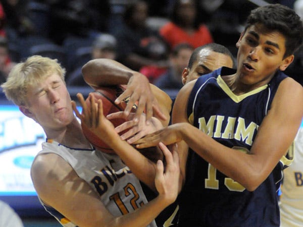 Laney’s Keegan Czesak (left) fights for a loose ball with Miami’s Christian Garcia during this week’s Leon Brogden Holiday Basketball Tournament at UNCW.