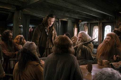 This image released by Warner Bros. Pictures shows Luke Evans, standing, in a scene from "The Hobbit: The Desolation of Smaug." (AP Photo/Warner Bros. Pictures)