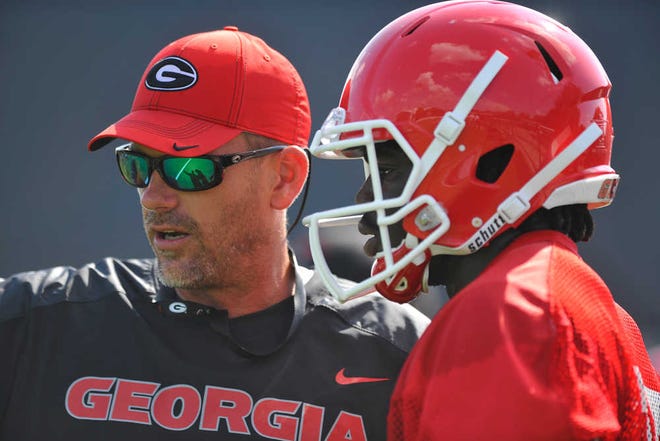 Georgia offensive coordinator Mike Bobo talks with running back A.J. Truman during the first day of fall football practice at the University of Georgia in Athens, Ga., Thursday, Aug. 1, 2013. (AJ Reynolds/Staff, @ajreynoldsphoto)