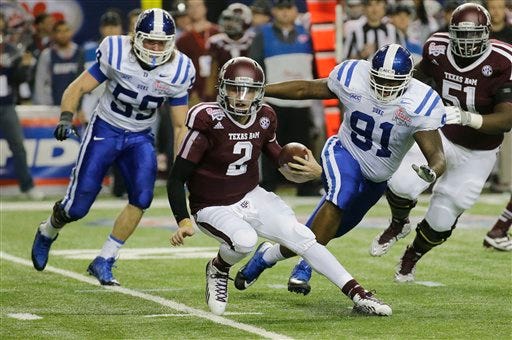 Texas A&M quarterback Johnny Manziel (2) is chased by Duke linebacker Kelby Brown (59) and nose tackle Jamal Bruce (91) in the first half of the Chick-fil-A Bowl NCAA college football game Tuesday, Dec. 31, 2013, in Atlanta.