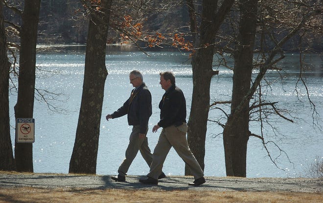 Enjoying the warm weather at Houghtons Pond in Milton,walkers walk along the water's edge, Wednesday, March 7, 2012.