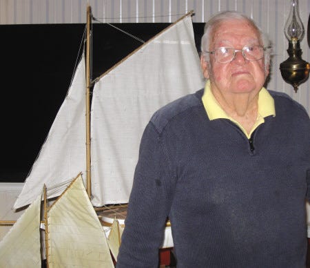 Don Smith stands in front of two sailing ships he made, in his York home.