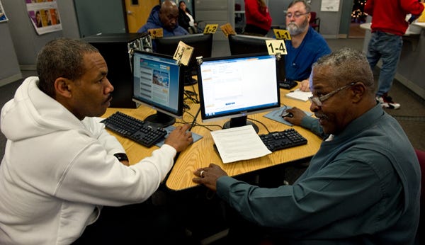 Tony Smith, 48, left, gets help from Willie Baker on updating his resume at San Joaquin County WorkNet on Tuesday.