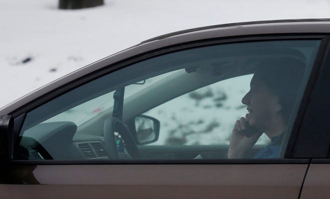 In this Dec. 19, 2013 photo, a motorist talks on a cell phone while driving on an expressway in Chicago.