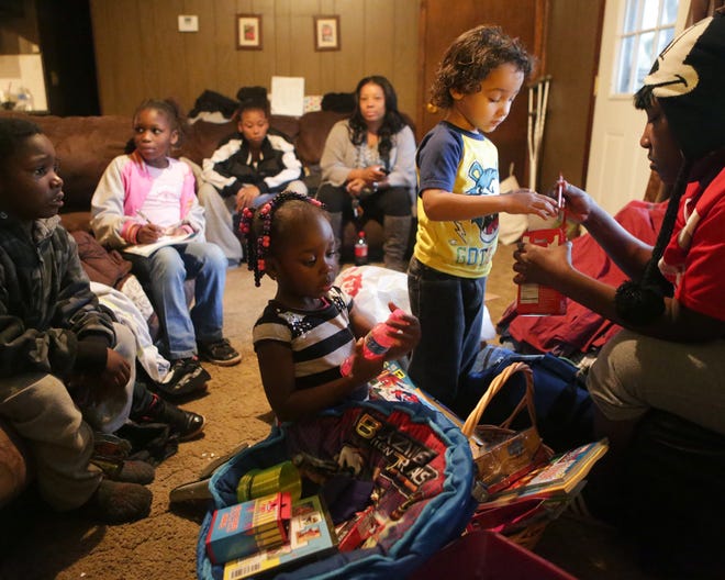 Shandrelle Smith, right, daughter of Cynthia Pete, helps younger family members look through donated toys on Thursday.