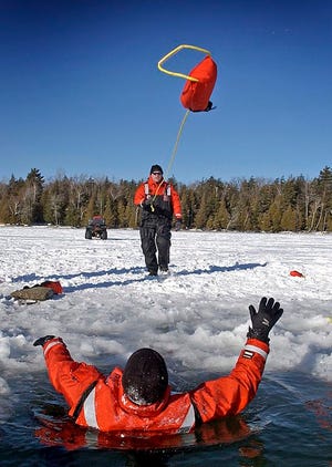 DNR conservation officers practicing rescue techniques on the ice make sure the rescuers remain well away from the thin ice.