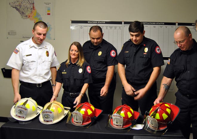 Newly promoted firefighters were awarded helmets and badges last month. Pictured are: Mattew Shultz, left, Deva Strode, Ben Pape, Mark Waters and John Fields.