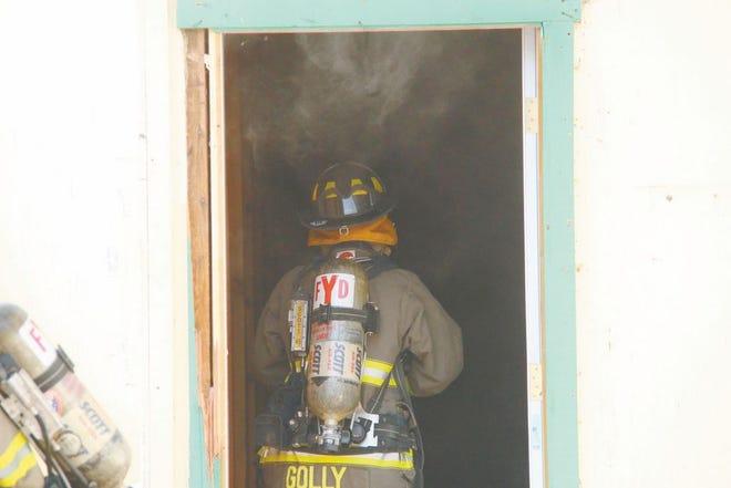 A Yreka firefighter enters the China Dragon's smoke-filled back entrance on New Years Day to determine the source of the flames. Daily News Photo/Kevin Dickinson