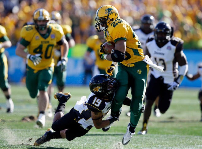 North Dakota State's John Crockett fights for yardage as Juleon Killikelly-Lee attempts a tackle. The Bison are just the second FCS team to win three consecutive titles.