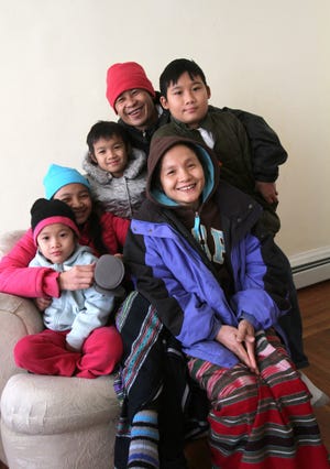 A refugee family from the Karen ethnic minority of Burma copes with their first major snowstorm since arriving in Rhode Island. Clockwise from left are Hser Teet, 7, on the lap of her sister, Ku Hsar, 14; son Kay Thay, 9; father Sher Yaw Htoo; son Mya Win, 12; and mother, Day May.