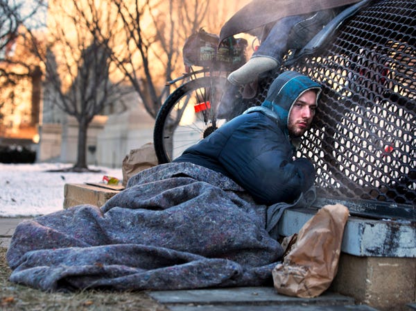 Nick warms himself on a steam grate with three other homeless men by the Federal Trade Commission, just blocks from the Capitol, during frigid temperatures in Washington on Saturday. A winter storm that swept across the Midwest this week blew through the Northeast on Friday, leaving bone-chilling cold in its wake. (AP Photo/Jacquelyn Martin)
