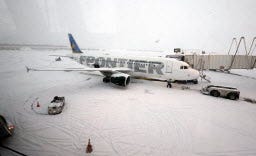 A Frontier airplane waits for passengers at O'Hare International Airport in Chicago, Thursday, Jan. 2, 2014. Another one to three inches of snow could fall across the Chicago metro area Thursday with even more falling in the southern part of the region, according to the National Weather Service.