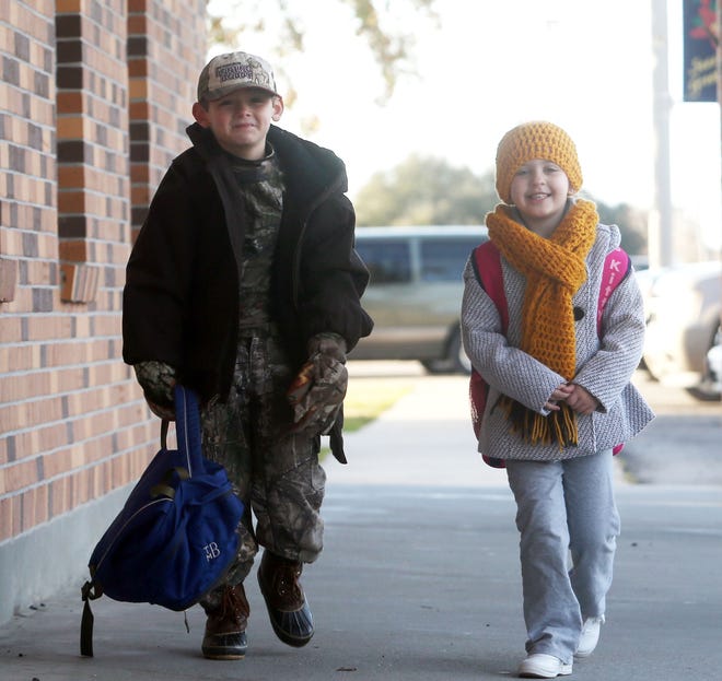 Trey Babin (left) and Emily Faucheaux, both 6, walk into St. Genevieve Elementary this morning in Thibodaux.