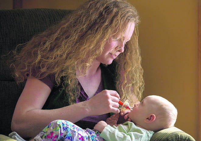 Carly Tangney-Decker gives medicine to her 8-month-old daughter, Mabel, who suffers from a rare disorder resulting in seizures. She hopes New York soon may allow use of medical marijuana, which might aid Mabel.