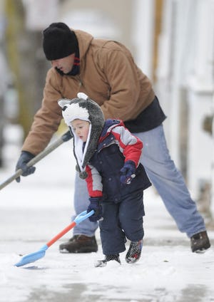 A son helps his father shovel the walk during a snowfall earlier this month in Newport. Shoulder and back injuries from shoveling are common, though they can be prevented by paying attention to form, taking frequent breaks and not attempting to lift too much snow with each stroke, experts say.