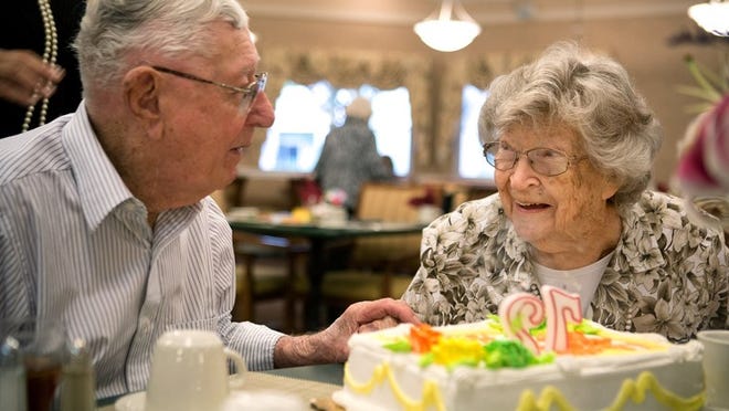 Claudine Southgate, 91, right, smiles at her husband Howard Southgate, 94, left as they celebrate their 72nd wedding anniversary with cake at Atria Meridian independent living community on Tuesday4 in Lantana. The Southgates were high school sweethearts who married just a month after the start of WWII. (Madeline Gray/The Palm Beach Post)