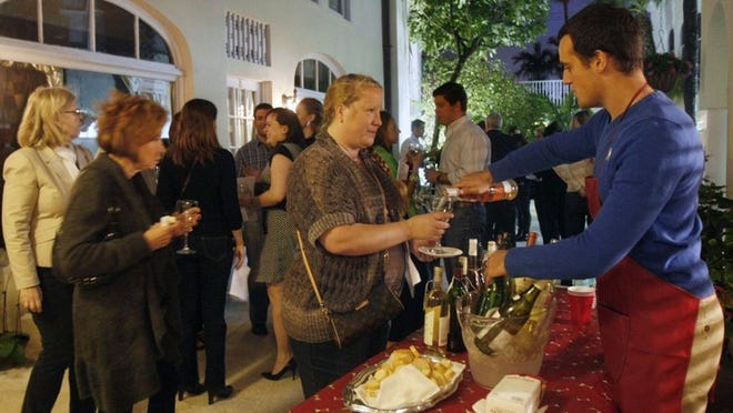 A small crowd braves a chilly evening for a wine tasting in the courtyard behind The French Wine Merchant on Palm Beach for a wine tasting Friday, Jan. 3, 2014. (J. Gwendolynne Berry/The Palm Beach Post)
