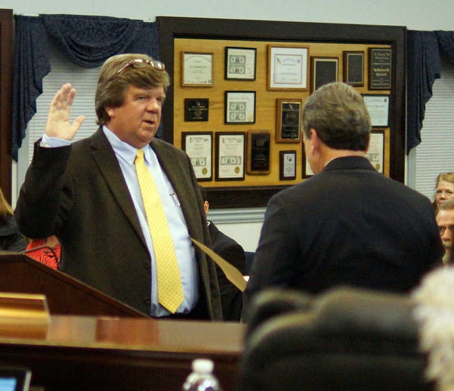 Jamie Parker/Bryan County Now Richmond Hill city councilmember Johnny Murphy, left, raises his hand to take the oath of office from Ga. Sen. Buddy Carter Tuesday night.