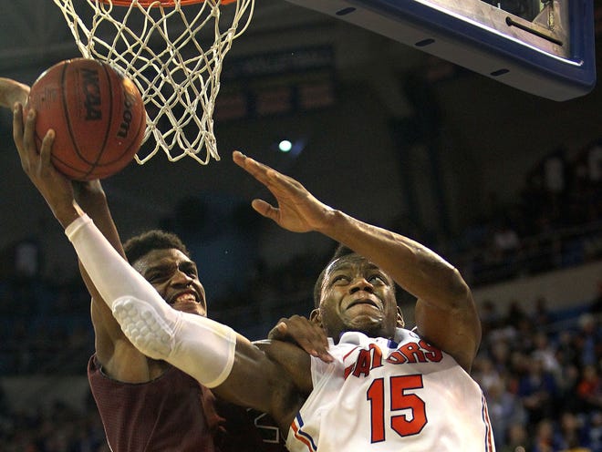 South Carolina center Demetrius Henry (21) fouls Florida forward Will Yeguete (15) as he takes a shot during the second half of the Gators' 74-58 win over the Gamecocks on Wednesday at the O'Connell Center.