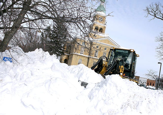 Cleanup begins around Hillsdale County as temperatures begin to rise Wednesday afternoon. Crews work to clear the large mounds of snow in the parking lot of the Hillsdale County Courthouse Wednesday afternoon with a front loader. The snow was piled in the courthouse lawn to make more room for parking.