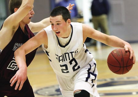 St. Thomas Aquinas High School’s Kevin Gould (right) dribbles around Goffstown’s Michael Bailey during Wednesday’s Division II boys basketball game in Dover. The previously unbeaten Saints suffered a 41-28 loss.