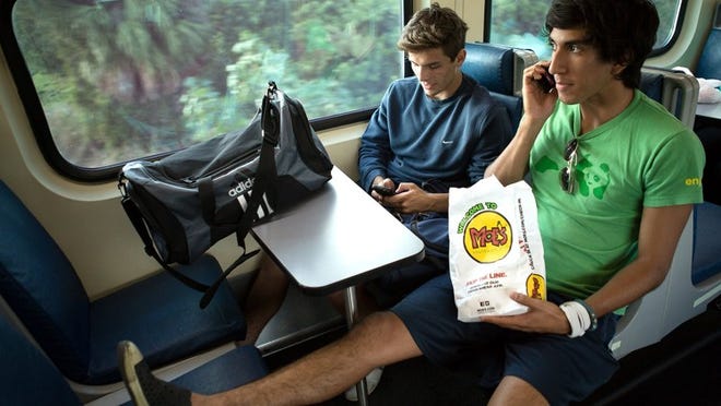 Ramiro Retes, 18, left, of Wellington, and Simon Marin, 19, right, of West Palm Beach, take a southbound Tri Rail train. For the rest of January, Retes and Marin will take the Tri Rail to Fort Lauderdale almost every weekday to practice soccer before they compete in trials in Argentina. Tri Rail will celebrate its 25th anniversary on Jan. 9, 2014. (Madeline Gray/The Palm Beach Post)