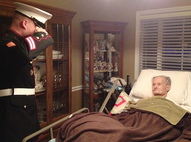 U.S. Marine Corps Sgt. Ronald Coonley salutes James H. Legg, who served in the Marines during World War II, in December 2013. Legg had been comatose for two weeks before briefly opening his eyes during Coonley's visit to Bryan Mosher's home in Prattville, Ala. SUBMITTED PHOTO