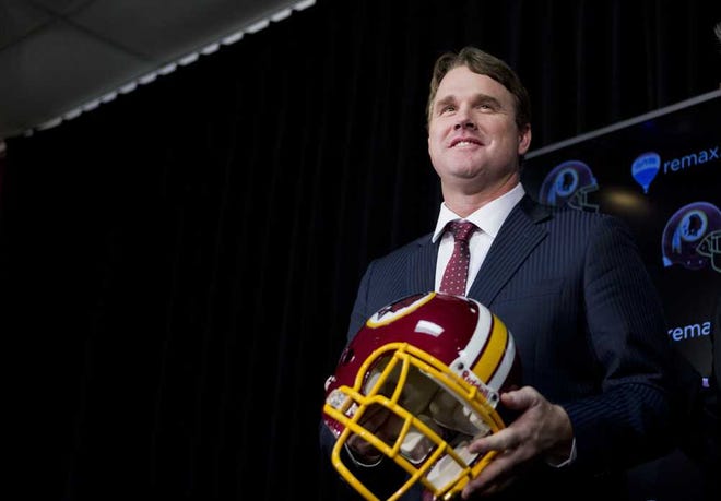 New Washington Redskins head coach Jay Gruden, holds a Redskins helmet at the Redskins Park in Ashburn, Va., Thursday, Jan. 9, 2014. Jay Gruden was introduced as the new Washington Redskins head coach, replacing Mike Shanahan and becoming the team's eighth head coach since Daniel Snyder purchased the franchise in 1999. (AP Photo/Manuel Balce Ceneta)