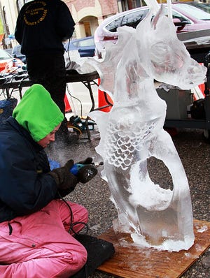 Grand Rapids Community College Ice Carving team member Jessica Miller works on some of the fine detail of her "maremaid" ice sculpture. Karla Juarez-Gonzalez/Sentinel Staff