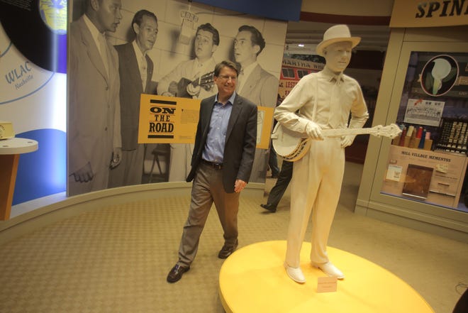 North Carolina Governor Pat McCrory walks by a statue of the late bluegrass legend Earl Scruggs inside of the Earl Scruggs Center Saturday afternoon. (Ben Earp/The Star)