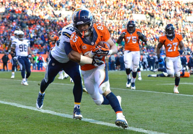 Denver Broncos wide receiver Wes Welker (83) crosses the goal line after a nine-yard touchdown pass against San Diego Chargers defensive back Darrell Stuckey (25) in the second quarter of an NFL AFC division playoff football game, Sunday, Jan. 12, 2014, in Denver. (AP Photo/Jack Dempsey)