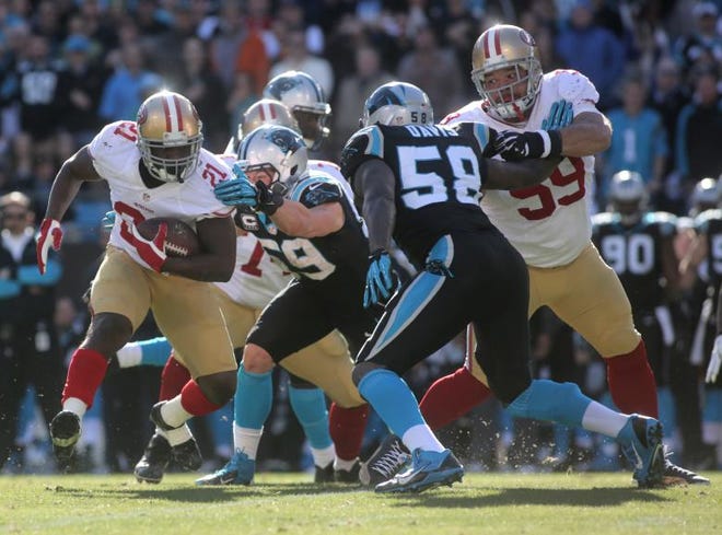 49ers running back Frank Gore (21) attempts to escape being tackled by Panthers linebacker Luke Kuechly as Carolina’s Thomas Davis also defends on the play. Gore had 84 rushing yards on 17 carries. San Francisco won 23-10 to advance to next Sunday’s NFC championship game at Seattle. It’s the 49ers’ third straight NFC title game appearance.