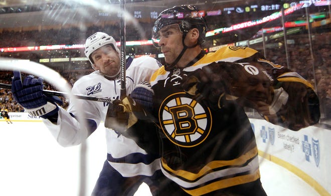 Boston Bruins defenseman Wade Redden, right, is checked by Tampa Bay Lightning right wing B.J. Crombeen during the first period of an NHL hockey game in Boston, Thursday, April 25, 2013.