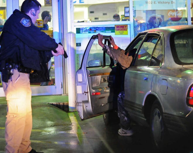 Corey Dickstein/Savannah Morning News  Savannah-Chatham police search suspects and the vehicle they were driving on Thursday evening during a traffic stop at a gas station at Victory Drive and Waters Avenue.