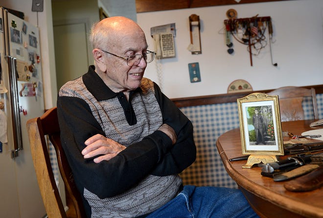 Edmund DeMeo, 89, of Milford, a U.S. Army veteran of World War II who fought in the Battle of the Bulge, with a photograph of himself in the service and other items he brought back from Germany. Daily News Staff Photo/Ken McGagh