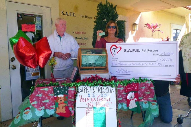 CONTRIBUTED Bob O'Brien, a SAFE Foster dad and Lynn Scheirer, sponsor, drew the winning ticket for SAFE'S December fundraiser.