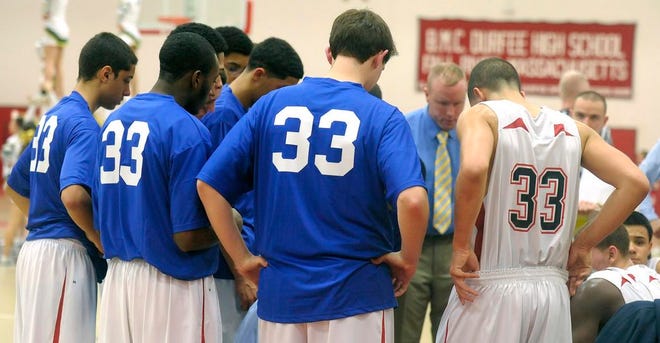 During a time-out, Durfee's Ryan Carter, far right, is seen in the the No. 33 jersey of the late Brandyn Fiola. When not on the court, the rest of the team, at left, wore blue T-shirts bearing Fiola's number.