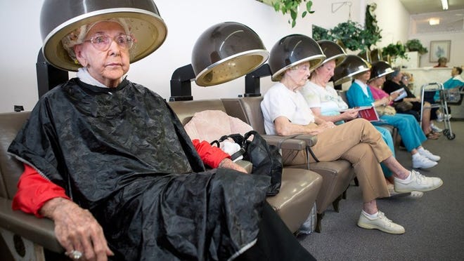 Nellie Larimore, 99, left, of North Palm Beach, waits for her hair to dry after receiving a perm at Fashionaire Salon in Lake Park on Dec. 27, the last Friday that the salon was open. Elaine Hill, of Palm Beach Gardens, the owner of Fashionaire Salon, has been doing Larimore’s hair for the past 30 years. (Madeline Gray/The Palm Beach Post)