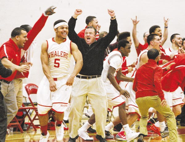 New Bedford High head coach Tom Tarpey, center, along with his players and coaches celebrate Ben Clark's put back with seconds remaining to give the Whalers a 68-66 victory over Brockton.