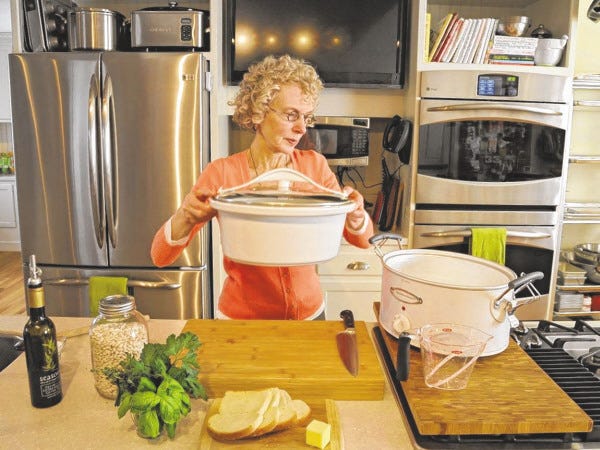 Clem Murray, Philadelphia Inquirer/MCT
Cookbook author Phyllis Good has finished assembling a white bean casserole and puts the liner into a Hamilton Beach slow-cooker in the test kitchen of Good Cooking Store.
Clem Murray, Philadelphia Inquirer/MCT
Cookbook author Phyllis Good has finished assembling a white bean casserole and puts the liner into a Hamilton Beach slow-cooker in the test kitchen of Good Cooking Store.