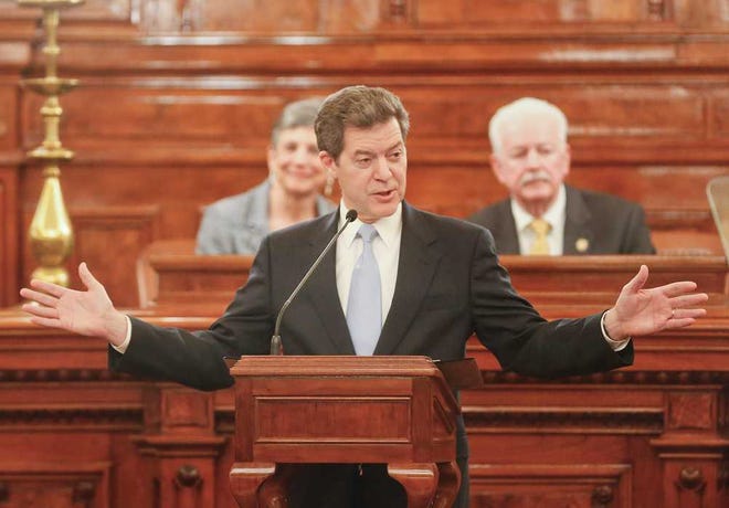 Gov. Sam Brownback talks about the increase in jobs throughout the state during his State of the State speech Wednesday night in the House chambers. Behind Brownback are Senate President Susan Wagle, R-Wichita, and House Speaker Ray Merrick, R-Stilwell.