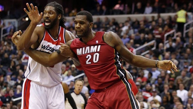 Miami center Greg Oden — guarded here by Washington’s Nene — made his first appearance with the Heat on Wednesday night after being sidelined by knee problems for more than four years. (AP Photo/Alex Brandon)