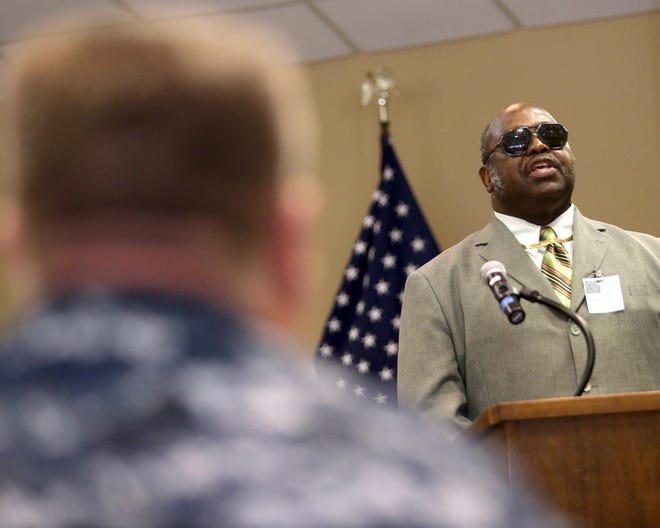 Capt. P.E. Dawson III, commanding officer of Naval Surface Warfare Center Panama City Division, listens as the Rev. Rufus Wood Jr. gives the keynote address during the Martin Luther King Jr. Observance Ceremony at Naval Support Activity Panama City on Thursday.